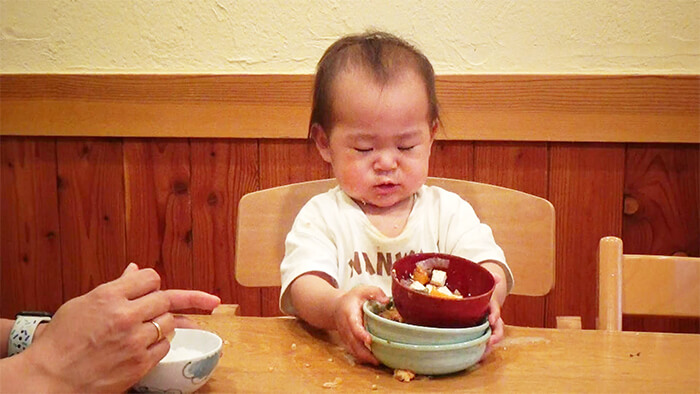 おちゃわんを重ねるあかちゃんの写真