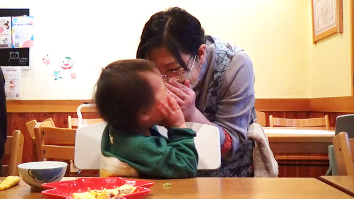 笑顔で内緒話ごっこをする赤ちゃん