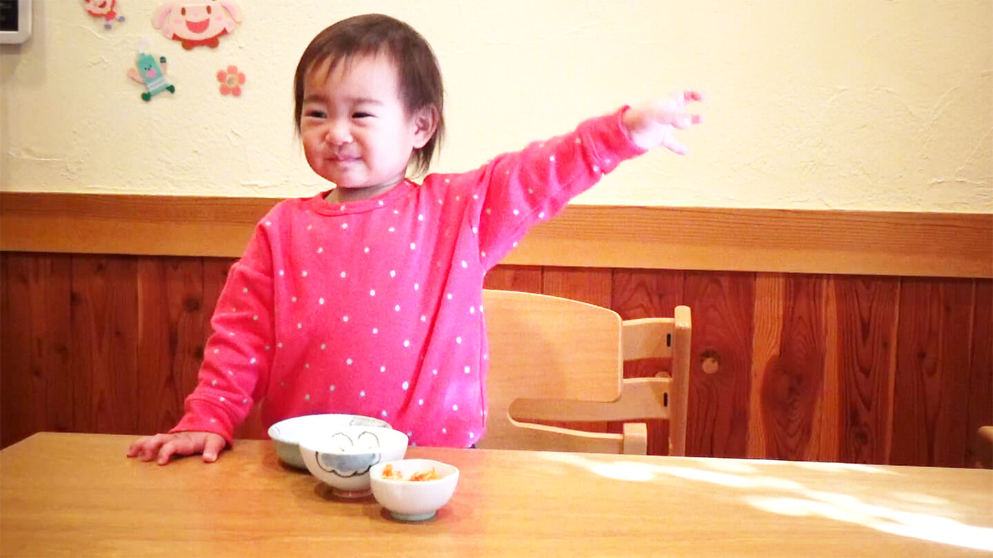 赤ちゃんがご飯を食べて喜んでいる様子