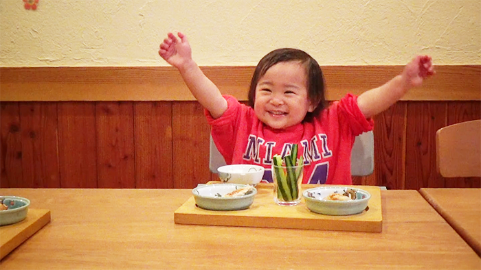 プレ幼児食期の手づかみ食べをして喜ぶ幼児の様子