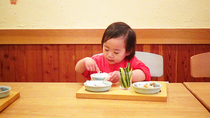 プレ幼児食期の手づかみ食べをして喜ぶ幼児の様子