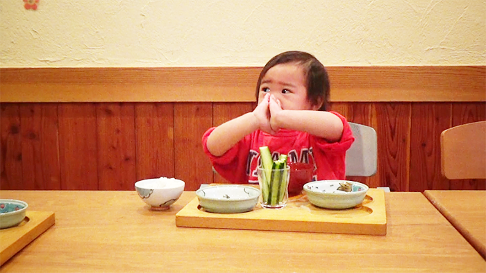 プレ幼児食期の手づかみ食べをして喜ぶ幼児の様子