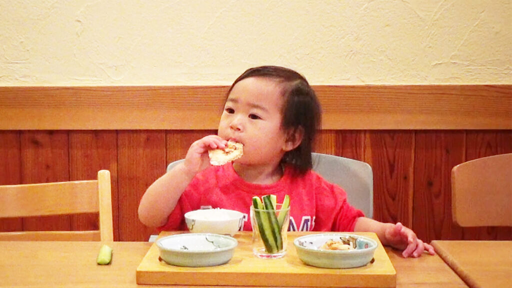 プレ幼児食期の手づかみ食べをして喜ぶ幼児の様子