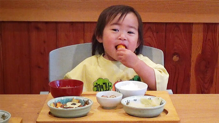2歳の幼児が手づかみで食事をしている様子
