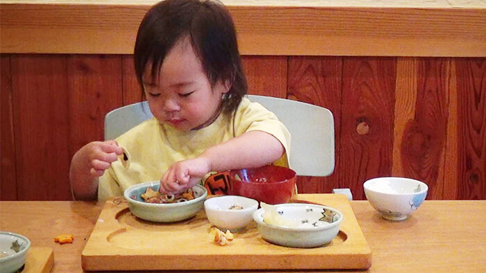 2歳の幼児が手づかみで食事をしている様子