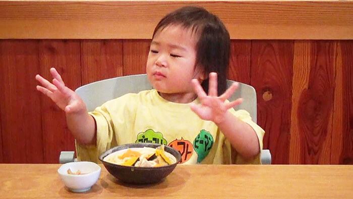 幼児が手づかみで食事をする様子