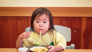 幼児がうどんをすする様子