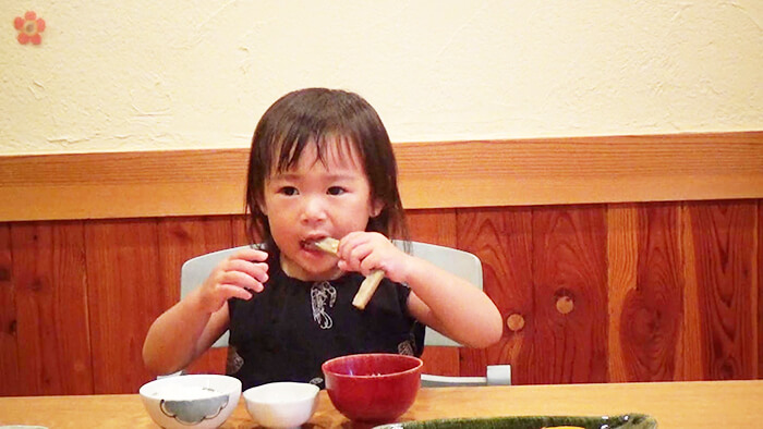 幼児がごぼうを手づかみでかじっている様子