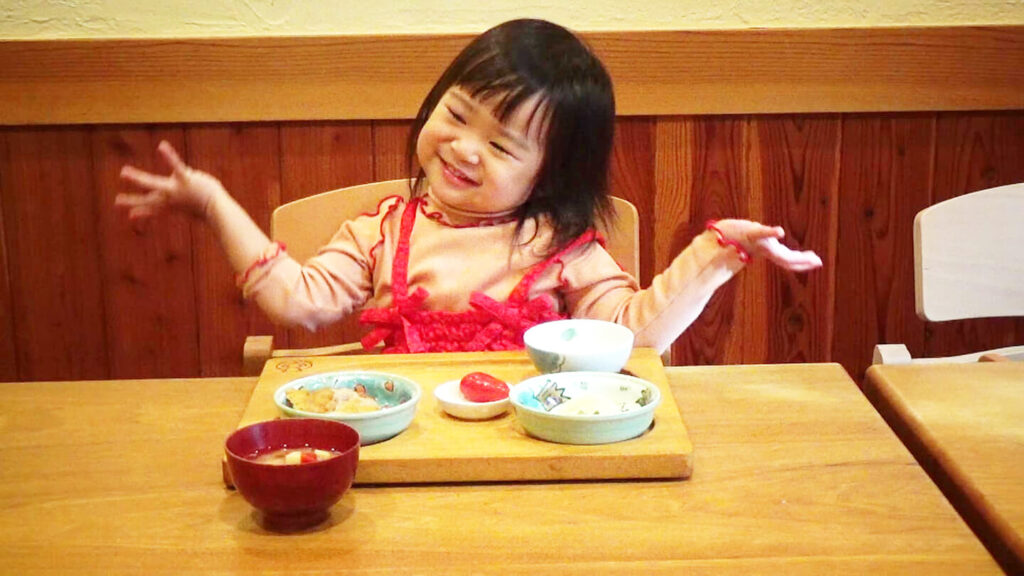 幼児が楽しそうに食事をしている様子